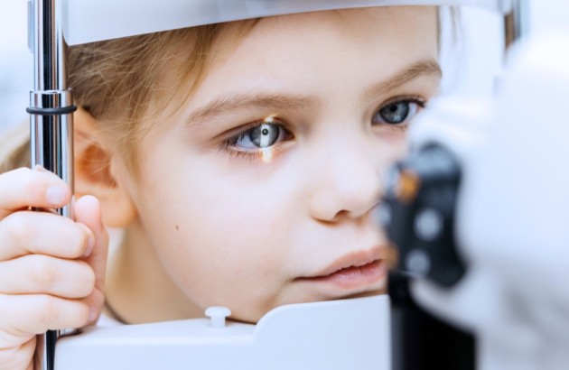 Medizintechnik-Junges Mädchen bei einer Sehuntersuchung mit ophthalmologischen Geräten, mit Schwerpunkt auf der Augenuntersuchung