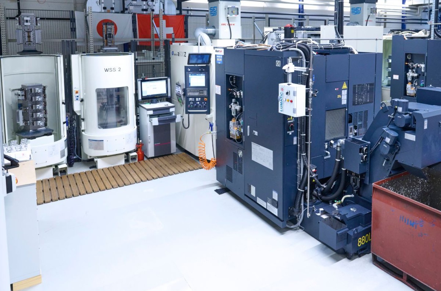 Makino 4 und 5 Achsen Fräsmaschinen stehen in einem Produktionsraum im Hintergrund eine Schweizer und eine japanische Flagge